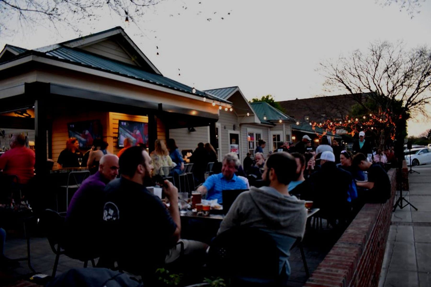 People gathered at outdoor tables at Aviator’s TapHouse patio