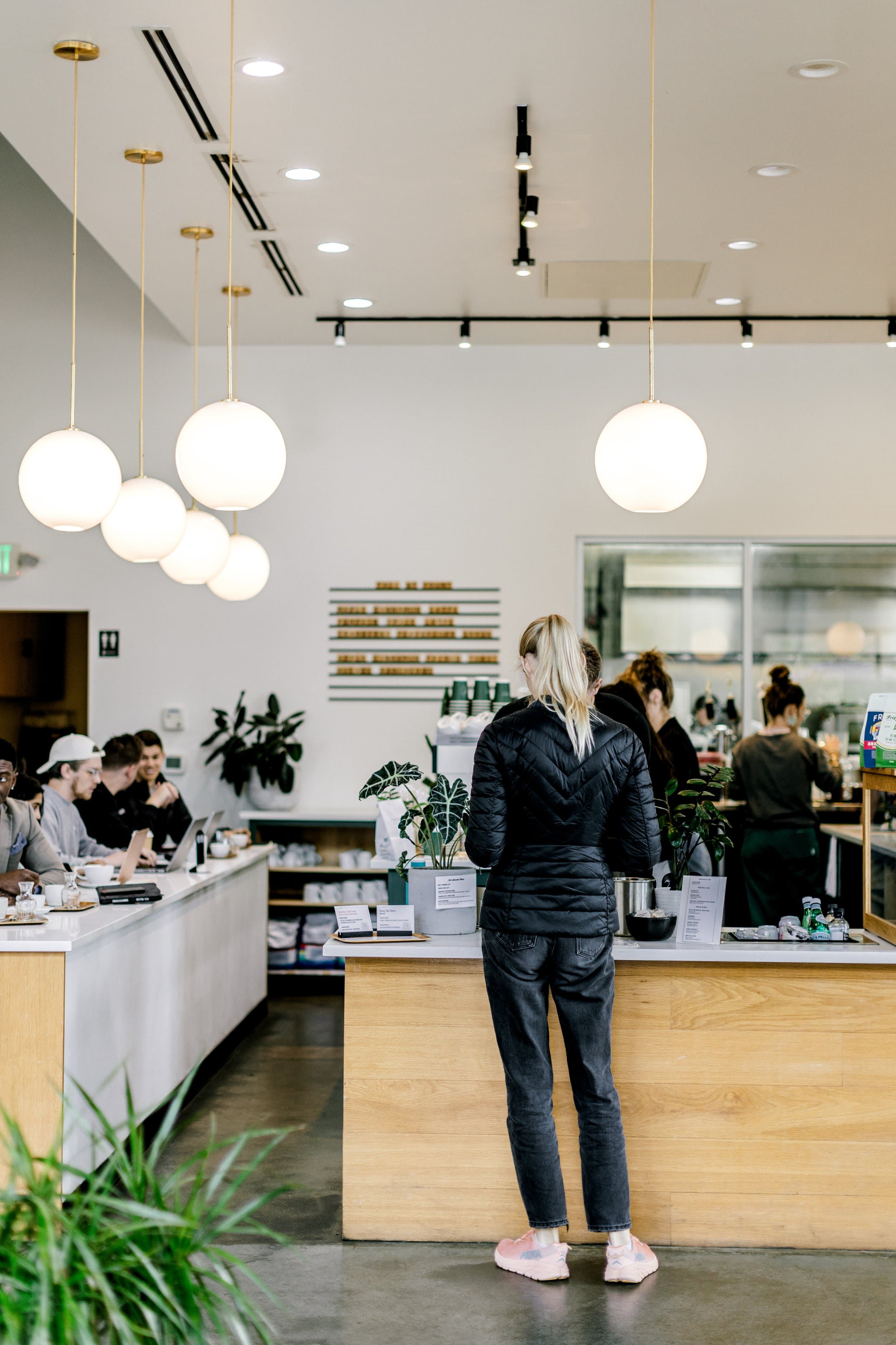 A person at the counter inside the bright café at Fount Coffee + Kitchen