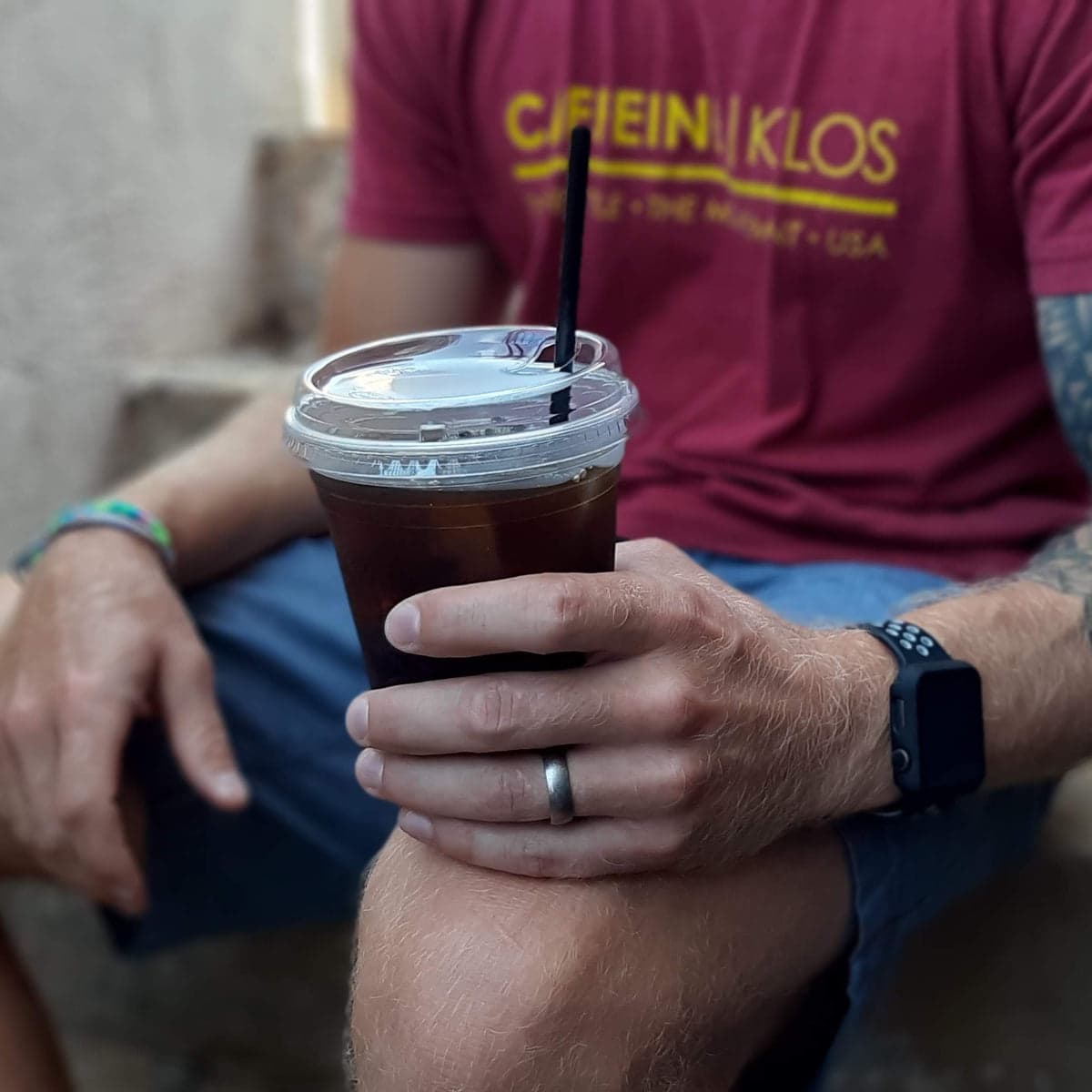 A person holding an iced coffee in Full Bloom Coffee’s café photograph