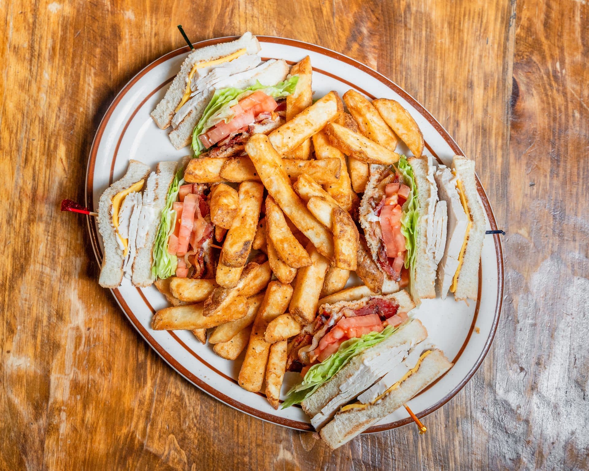 Sandwiches and fries on a wooden table in McLean’s Ole Time Cafe’s photograph