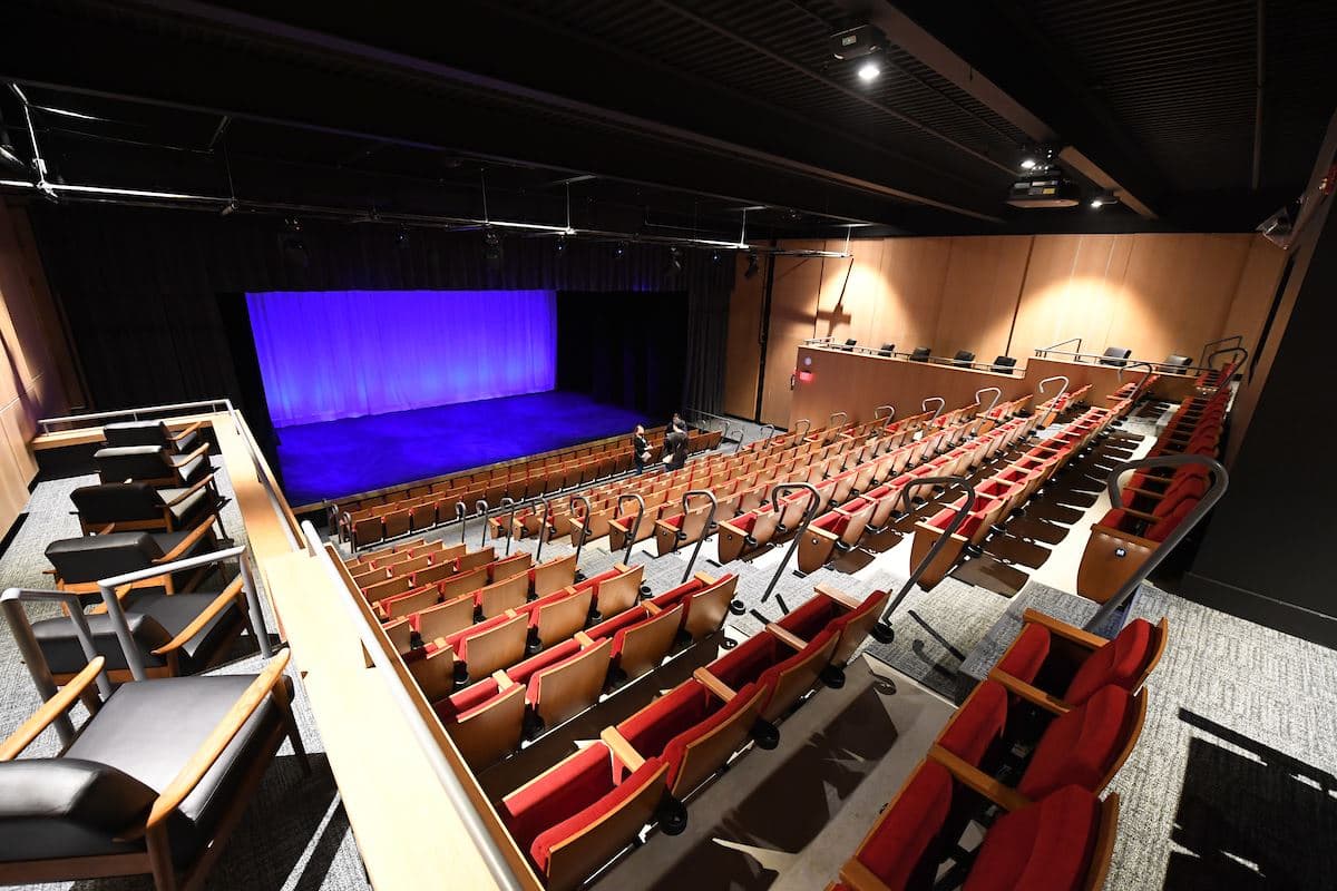 Rows of red seats facing a purple-lit stage inside Fuquay-Varina Arts Center
