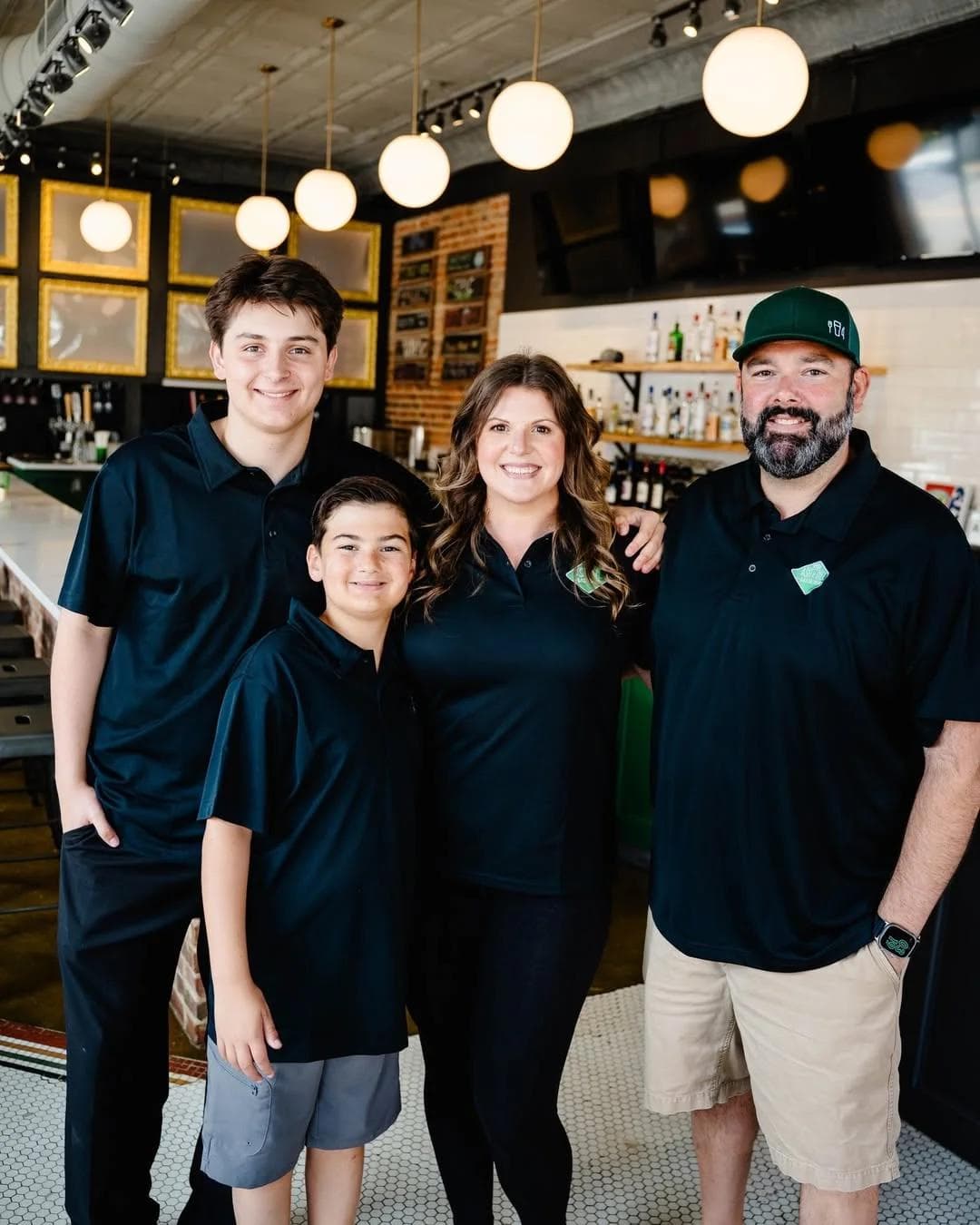 Four smiling members of the Ash & Dill family inside the restaurant