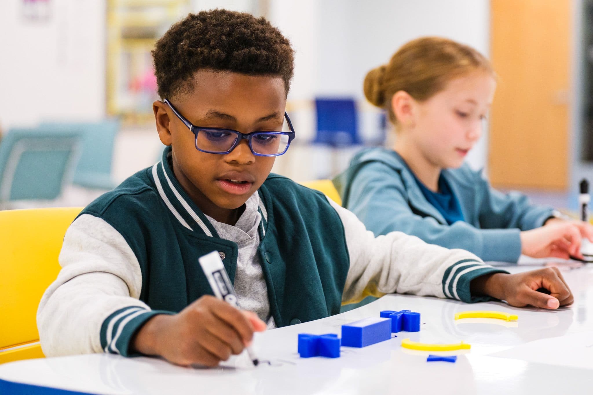Two WCPSS students working with classroom materials at their desks